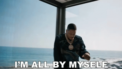 A Man Is Standing In Front Of A Window With The Words `` I 'M All By Myself '' Written On The Bottom . GIF