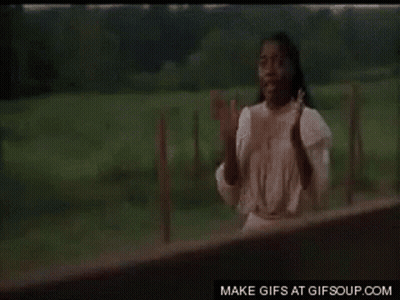 A Man Is Standing In Front Of A Wooden Fence . GIF