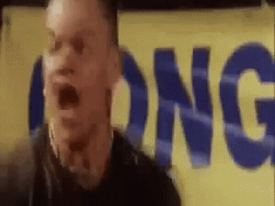 A Man Is Standing In Front Of A Yellow Sign That Says Long GIF