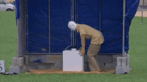 A Man Is Standing In Front Of An Explosion With Sparks Coming Out Of It . GIF