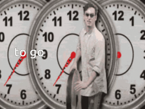 A Man Is Standing In Front Of Three Clocks With The Words To Go Written On The Bottom GIF