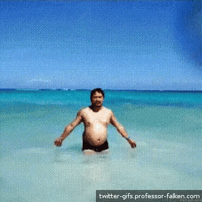 A Man Is Standing In The Ocean With Twitter-Gifs.professor-Falken.com Written On The Bottom GIF