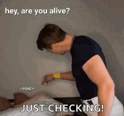 A Man Is Standing Next To A Bed With The Words `` Hey , Are You Alive ? '' And `` Just Checking ! '' GIF