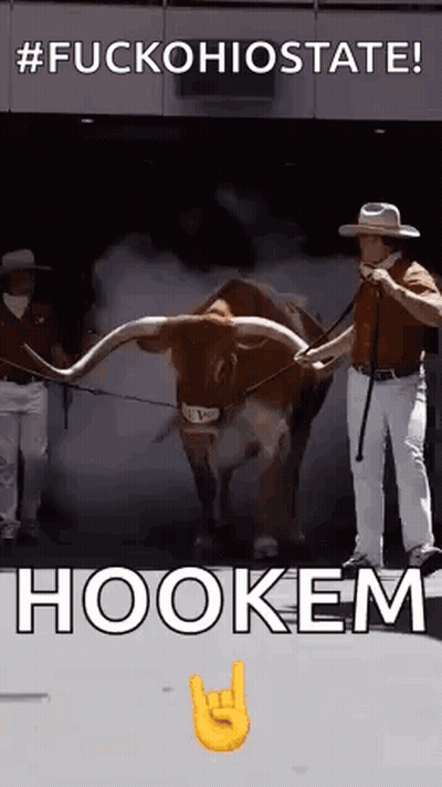 A Man Is Standing Next To A Brown Bull With Long Horns And Smoke Coming Out Of It . GIF