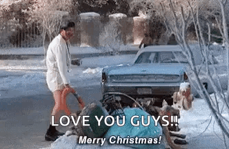 A Man Is Standing Next To A Car In The Snow Holding A Shovel . GIF