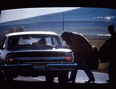 A Man Is Standing Next To A Car With A License Plate That Says ' Lc ' On It GIF