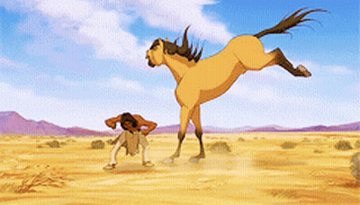 A Man Is Standing Next To A Large Horse In The Desert GIF
