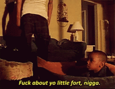 A Man Is Standing Next To A Little Boy Who Is Laying On A Couch And Says " Fuck About Yo Little Fort Nigga " GIF