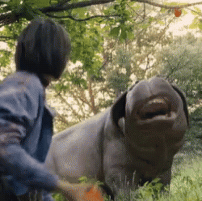 A Man Is Standing Next To A Stuffed Animal That Looks Like A Pig With Its Mouth Open . GIF