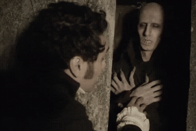 A Man Is Standing Next To A Wall Looking At A Monster . GIF