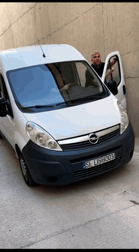 A Man Is Standing Next To A White Van With License Plate Sl L15h303 GIF