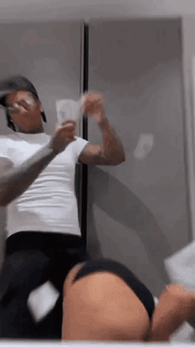 A Man Is Standing Next To A Woman In A Bathroom Holding A Bunch Of Money In Front Of A Mirror . GIF