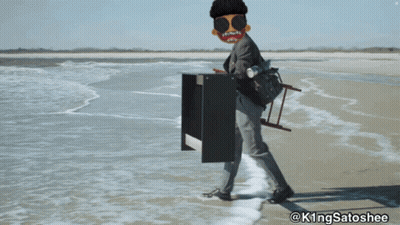 A Man Is Standing On A Beach With A Ladder On His Back And The Hashtag @Kingsatoshee On The Bottom GIF