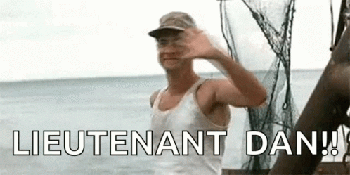 A Man Is Standing On A Boat In The Ocean Waving His Hand . GIF