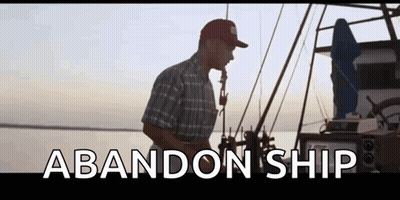 A Man Is Standing On A Boat In The Water With The Words Abandon Ship Written On The Bottom Of The Screen . GIF