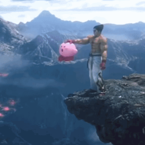 A Man Is Standing On A Cliff Holding A Pink Kirby Toy GIF