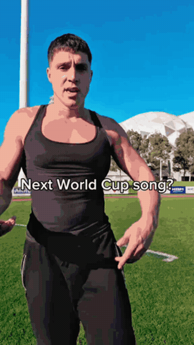 A Man Is Standing On A Field With The Words Next World Cup Song Written On His Chest GIF