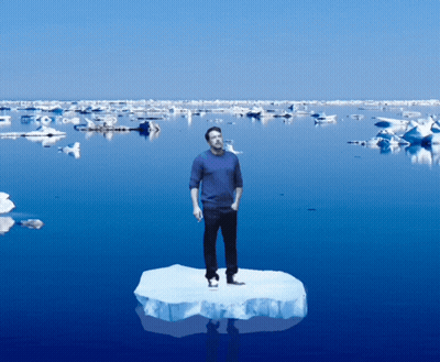 A Man Is Standing On A Piece Of Ice In The Middle Of The Ocean GIF