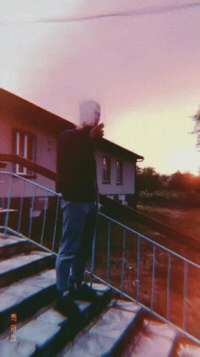 A Man Is Standing On A Set Of Stairs Taking A Picture With His Phone GIF