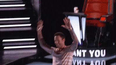 A Man Is Standing On A Stage With His Arms In The Air In Front Of A Sign That Says Ant You GIF