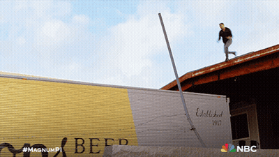 A Man Is Standing On The Roof Of A Building Next To A Beef Truck GIF
