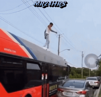 A Man Is Standing On The Roof Of A Bus With Mr24hrs Written On The Bottom GIF