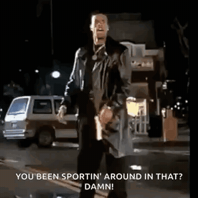 A Man Is Standing On The Side Of The Road Holding A Gun And Talking . GIF
