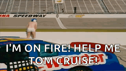 A Man Is Standing On Top Of A Race Car With The Words I 'M On Fire Help Me Tom Cruise GIF