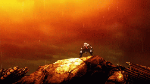 A Man Is Standing On Top Of A Rock With A Red Sky Behind Him GIF