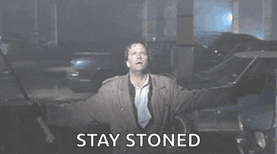 A Man Is Standing With His Arms Outstretched And The Words `` Stay Stoned '' Written On The Screen . GIF