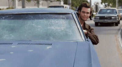 A Man Is Sticking His Finger Out Of A Car Window GIF
