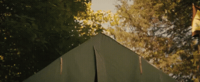 A Man Is Sticking His Head Out Of A Tent GIF