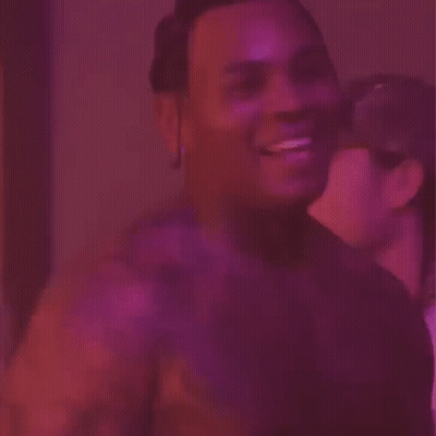 A Man Is Sticking His Tongue Out In Front Of A Purple Background . GIF