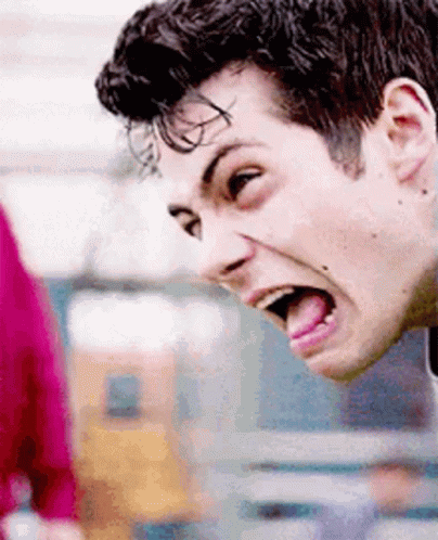 A Man Is Sticking His Tongue Out While Making A Funny Face . GIF