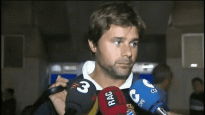 a man is surrounded by microphones including one that says rac on it