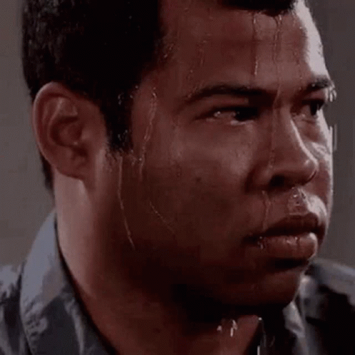 A Man Is Sweating Profusely And Looking At The Camera . GIF