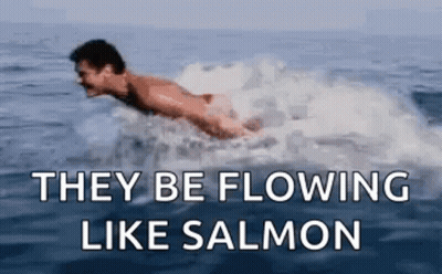A Man Is Swimming In The Ocean With The Words `` They Be Flowing Like Salmon '' Below Him . GIF