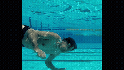 A Man Is Swimming Underwater In A Pool With His Mouth Open GIF