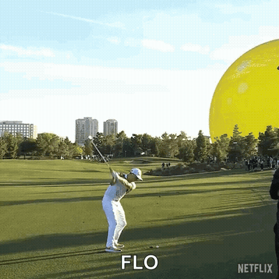 A Man Is Swinging A Golf Club On A Golf Course And The Word Flo Is Visible GIF