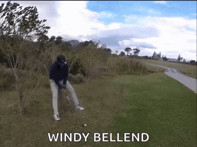 A Man Is Swinging A Golf Club On A Windy Day With The Words Windy Bellend Behind Him GIF