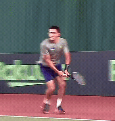 A Man Is Swinging A Tennis Racket On A Court In Front Of A Sign That Says Rakuten GIF