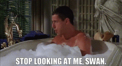 A Man Is Taking A Bath In A Bathtub Filled With Foam And Bubbles . GIF