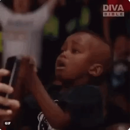 A Man Is Taking A Picture Of A Crowd Of People With His Phone . GIF