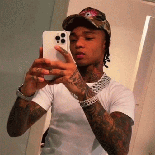A Man Is Taking A Picture Of Himself In The Mirror GIF
