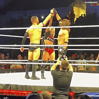 A Man Is Taking A Picture Of Two Wrestlers In The Ring GIF