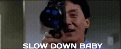A Man Is Taking A Picture With A Camera And The Words Slow Down Baby Are Below Him GIF