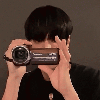 A Man Is Taking A Picture With A Video Camera . GIF