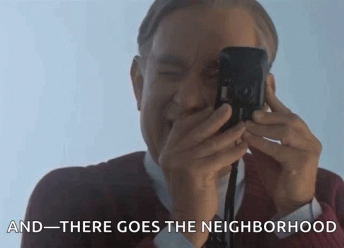 A Man Is Taking A Picture With The Words " And There Goes The Neighborhood " Behind Him GIF