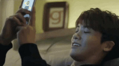 A Man Is Taking A Selfie With A Cell Phone . GIF