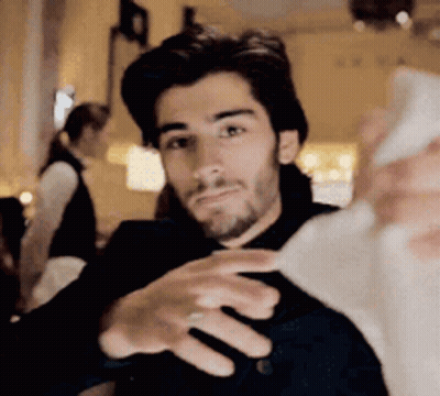 A Man Is Taking A Selfie With His Cell Phone . GIF